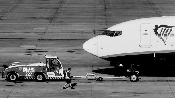 Employees use a tow truck to move an aircraft, operated by Ryanair Holdings Plc, on the tarmac at London Stansted Airport, operated by Manchester Airport Plc, in Stansted, UK, on Monday, Nov. 6, 2023. Ryanair will pay out a dividend of €400 million ($430 million) and plans to hand over about a quarter of annual profit to shareholders as Europe's biggest discount airline benefits from growing traffic. Photographer: Chris Ratcliffe/Bloomberg