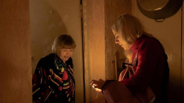 Til højre 42-årige Alina Diatjenko, der giver en lyspære til den 77-årige pensionist Nina Sydorenko, der bor i en kommunal lejlighed i Kyiv, hvor hun i størstedelen af tiden hverken har vand eller strøm efter russernes gentagne luftangreb på infrastrukturen.
