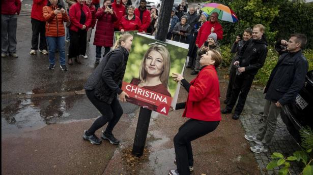 Statsminister Mette Frederiksen hjælper Christina Krzyrosiak Hansen med at hænge valgplakater op i Holbæk.