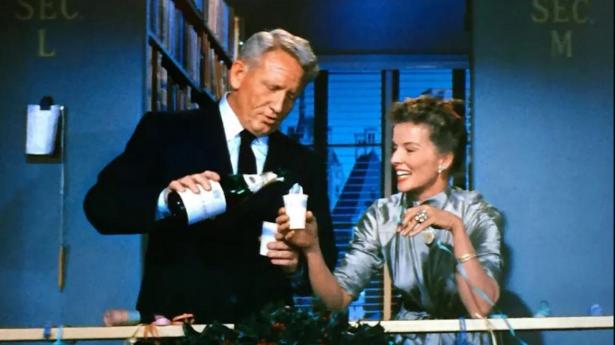 Spencer Tracy og Katharine Hepburn som Richard Sumner og Bunny Watson, der holder julefest på kontoret i filmen “Desk Set” fra 1957.