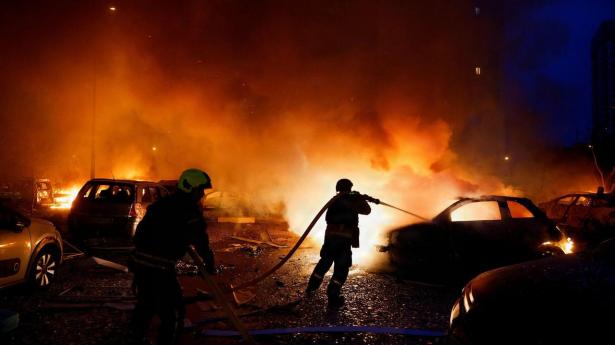 Brandmand kæmper natten til mandag mod flammerne ved et boligområde med etageejendomme, der er blevet hårdt ramt af et russisk missilangreb.