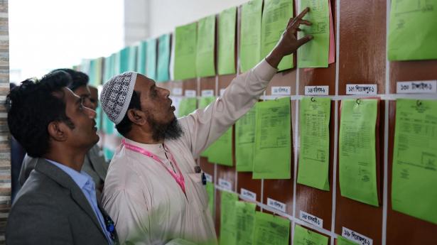 Folk ses fredag i Dhaka i Bangladesh betragte resultater fra valg, hvor bnp i optællingen ser ud til at have taget sikker sejr.