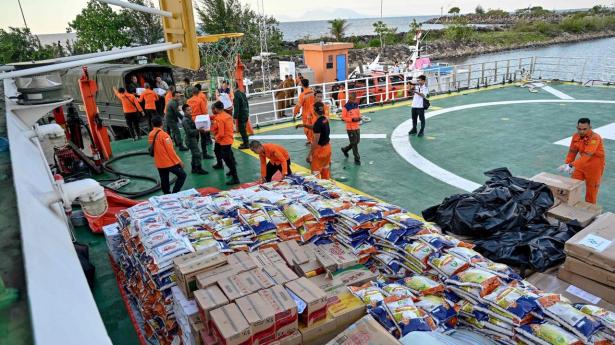 Ansatte ved det indonesiske redningsagentur læsser forsyninger til de overlevende efter oversvømmelser i et boligområdet i Banda Aceh i provinsen Aceh.