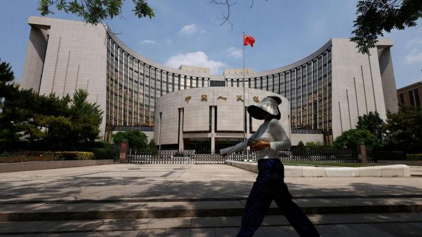 A person walks past the headquarters of the People's Bank of China, in Beijing, China May 7, 2025. REUTERS/Tingshu Wang TPX IMAGES OF THE DAY