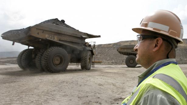 En colombiansk arbejder ser minelastvognene køre væk fra Carrejón-kulminen, der er ejet af BHP, Glencore og Anglo American. Arkivfoto: Jose Miguel Gomez/Reuters/Ritzau Scanpix