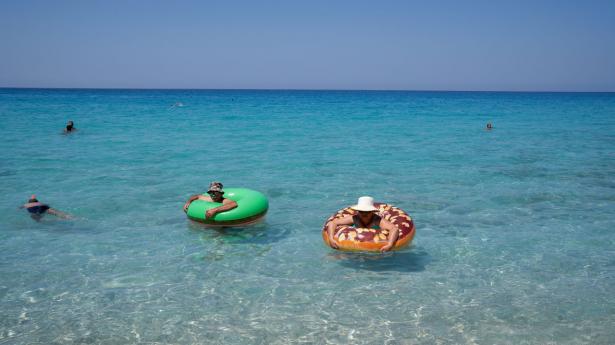 Det var muligt at rejse til Grækenland sidste sommer, men aktiviteten var langt under det normale. Her bades der ved en strand på øen Lefkada i juli 2020. Arkivfoto: Dimitris Rapakousis/Reuters/Ritzau Scanpix