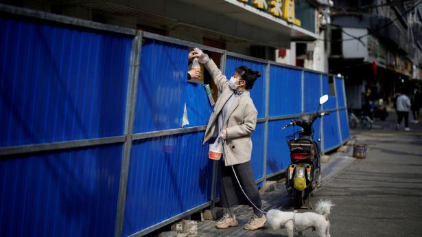 En kvinde modtager madvarer under nedlukningen i Wuhan, hvor hele boligkvarterer blev lukket af fra omverdenen. Foto: Aly Song/Reuters/Ritzau Scanpix