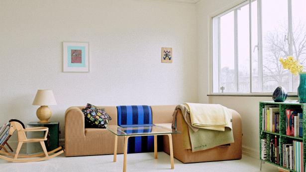 Sofa i fire moduler fundet på lagersalg hos Paustian, hvor de blev solgt som separate moduler. Parret fik det hele til en god pris, fordi de egentlig ikke hørte sammen. Stoffet er fra Kvadrat – det blå er lavet i samarbejdet Kvadrat X Raf Simons. Sofabordet er Alvar Aalto, købt på lauritz.com, gyngehesten er fundet i den lokale Mødrehjælpen, sidebordet er fra Muller Van Severen, bambuslampe fundet på dba.dk til 100 kr., pude fra Svenskt Tenn og tæpper fra hhv. Arket og en genbrugsbutik. Billeder over sofaen af Tal R og Daniel Eatock.