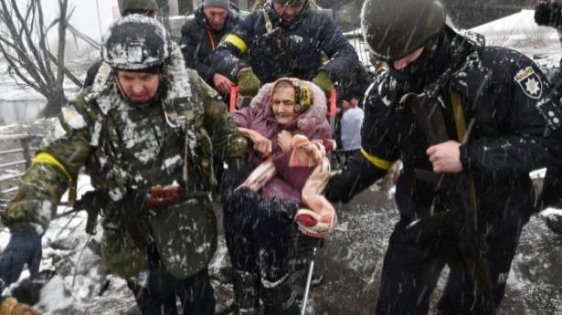 En ældre kvinde hjælpes over en ødelagt bro over floden Irpin, en biflod til Dnepr. Foto: Sergei Supinsky/AFP/Ritzau Scanpix