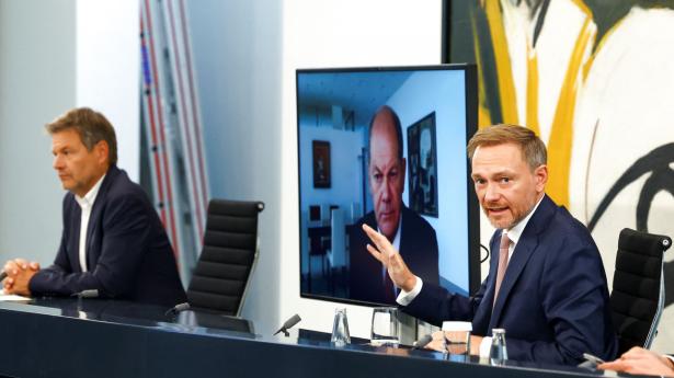 Den tyske kansler Scholz deltog i regeringens pressemøde via videolink, fordi han er i coronaisolation. T.h. ses finansminister Christian Lindner og t.v. økonomi- og klimaminister Robert Habeck. Foto: Lisi Niesner/Reuters/Ritzau Scanpix
