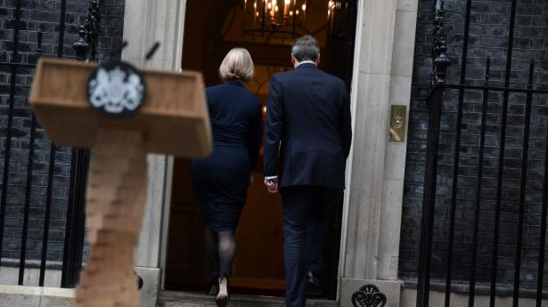 Premierminister Liz Truss og hendes mand, Hugh O’Leary, forsvinder ind i Downing Street nr. 10 efter at have erklæret, hun træder tilbage. Foto: Daniel Leal/AFP/Ritzau Scanpix