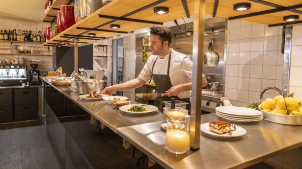 Fra restauranten har man udsigt til det åbne køkken, hvor kokkene laver overvejende italiensk mad med enkelte franske indspark. Foto: Simon Fals