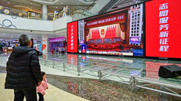 En enlig kineser i Qingzhou ser på en livetransmission fra åbningen af Folkekongressen. Foto: AFP/Ritzau Scanpix