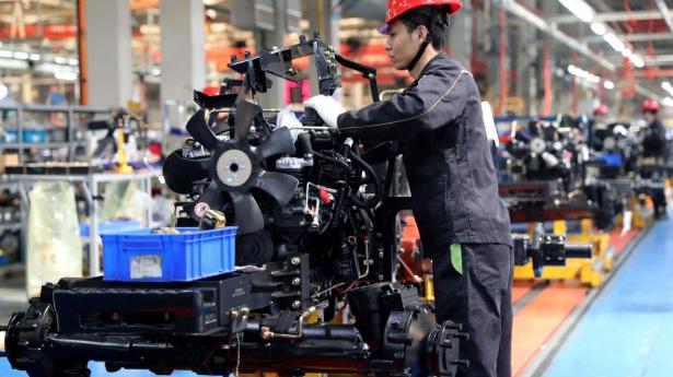 This photo taken on April 26, 2023 shows an employee working on a tractor assembly line at a factory in Linyi, in China's eastern Shandong province. (Photo by AFP) / China OUT