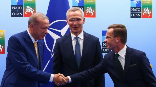 Den tyrkiske præsident Tayyip Erdogan og den svenske premierminister Ulf Kristersson giver hånden ved siden af NATO's generalsekretær Jens Stoltenberg. Foto: Yves Herman/Reuters/Ritzau Scanpix