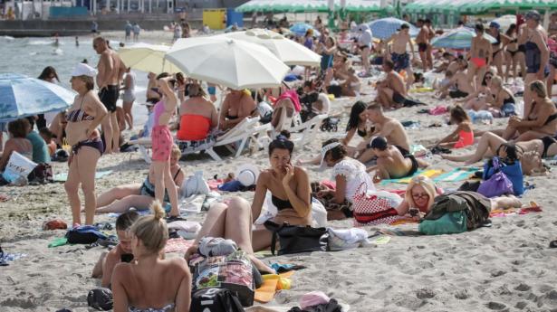 Sådan kan livet også se ud ved den ukrainske Sortehavs-kyst i midten af august. Stranden er genåbnet, efter den sidste år blev lukket på grund af de miner, som både russerne og ukrainerne havde placeret ud for havnene i Odesa og Mykolaiv. Foto: Stringer/Reuters/Ritzau Scanpix