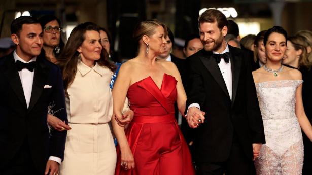 Trine Dyrholm i rød kjole på den røde løber i Cannes. Sammen med bl.a. instruktør Magnus von Horn og skuespiller Vic Carmen Sonne, der måske vinder en pris for “Pigen med nålen”. Foto: Valery Hache/Ritzau Scanpix