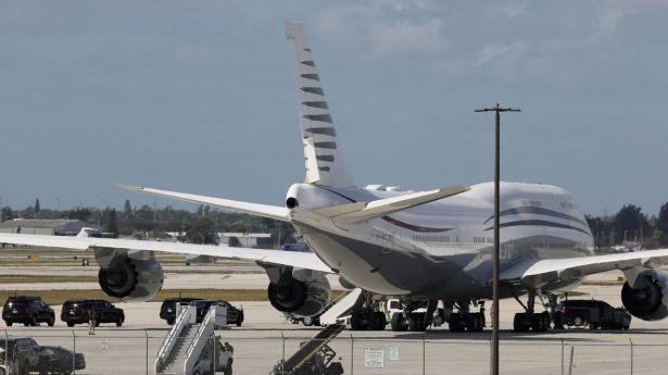 Tæt på jumbojetten fra Qatars kongefamilie ses præsident Donald Trumps mange biler, da han i februar i West Palm Beach, Florida så nærmere på flyet, han nu får som gave.