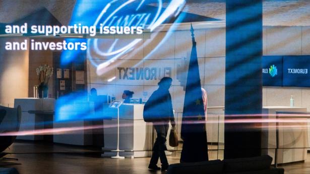 Visitors in the lobby of the Euronext NV stock exchange in La Defense business district of Paris, France. Photographer: Nathan Laine/Bloomberg