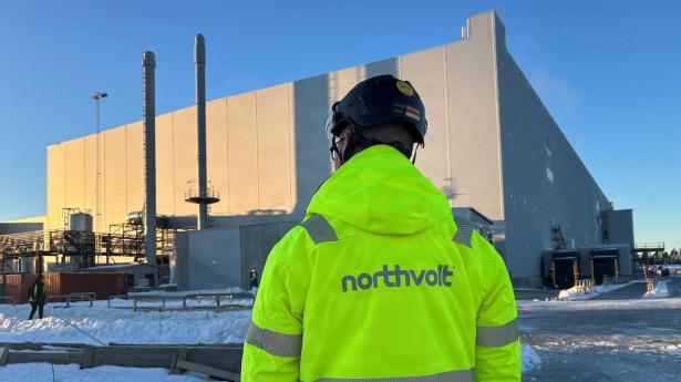 A man stands in front of the Northvolt Ett factory in Skelleftea
