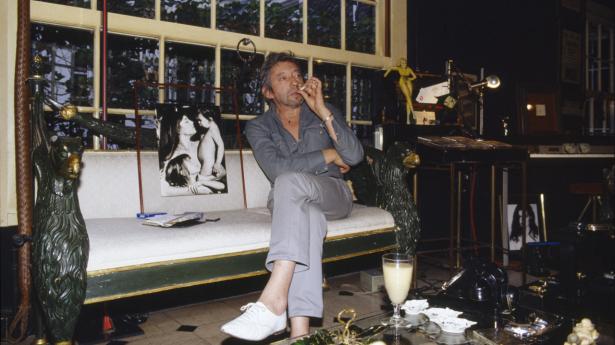 Serge Gainsbourg i sit hjem i Paris, det formodes ikke at være mælk, der er i glasset. Arkivfoto: Jerome Prebois/Kipa/Sygma via Getty Images