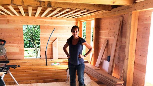 Signe Wenneberg i sit sommerhus i Nordsjælland bygget på pæle og med genbrugsvinduer. Foto: Signe Wenneberg