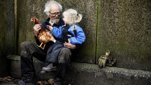 Morfar Ehlers driver sammen med sin kone et landbrug med 64 hektar agerjord samt dyr, skov og hede. Her med Kathrine på to år på skødet. Foto: Robert Attermann