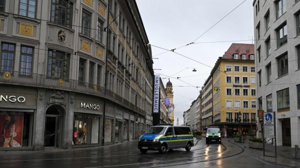 To politibiler på patrulje i de ellers tomme gader i München lørdag. Som mange andre steder er det sociale liv stærkt begrænset af coronavirusset - og det samme er butikkernes indtjening.