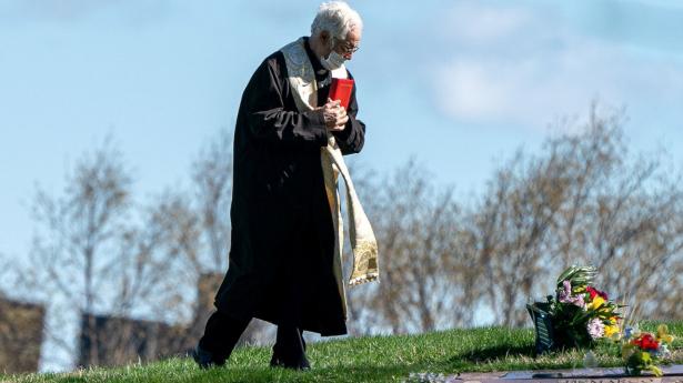En præst med mundbind ses her ved Green-Wood Cemetery i Brooklyn i New York City.