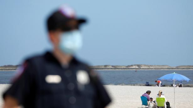 En vagt holder øje med strandgæsterne på Long Island, New York, hvor strandene fredag genåbnede i forbindelse med Memorial Day-weekenden.