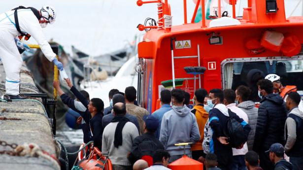 Migranter er reddet op af den spanske kystvagt ved Gran Canaria. Billedet er fra havnebyen Arquineguin på Gran Canaria, hvor migranter får udleveret mundbind.