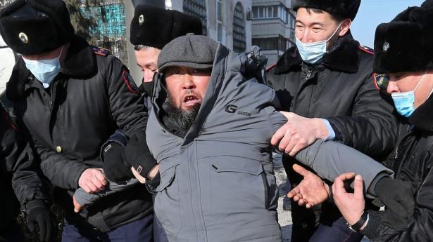 En demonstrant føres søndag væk af politiet i Kasakhstans tidilgere hovedstad, Almaty. Det sker under en demonstration arrangeret af oppositionen på valgdagen.