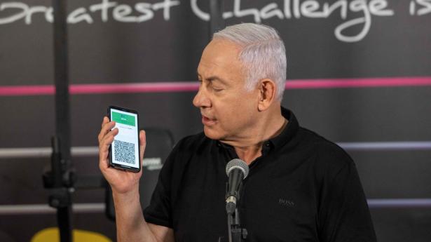 Premierminister Benjamin Netanyahu fremviser her det grønne vaccinepas på sin telefon forud for en delvis genåbning søndag.