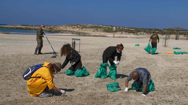 Frivillige er i gang med at rense Israels strande for tjære. Her er det en strand syd for Haifa.