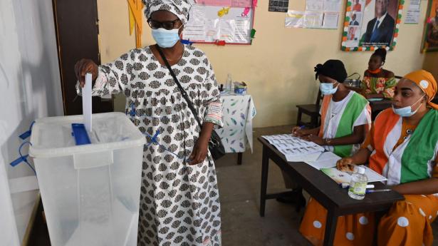 En kvinde lægger lørdag sin stemme i valgboksen i Elfenbenskystens største by, Abidjan. Valget er denne gang forløbet roligt, men landet er stadig mærket af de blodige uroligheder i forbindelse med præsidentvalg i 2010 og 2020, der kostede tusinder livet.