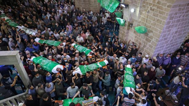 Palæstinensere i Gaza bærer ligene af 13 militante Hamas-medlemmer, der blev dræbt i israelske luftangreb, ved deres begravelser i Gaza City torsdag.
