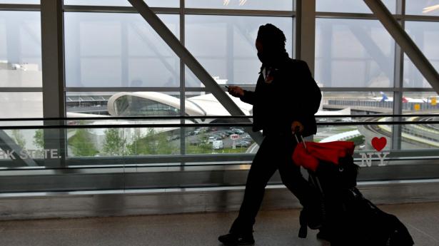 En passager er på vej gennem JFK-lufthavnen i New York. Selv om USA nu lukker op for, at amerikanerne kan rejse til flere lande, kan der være indrejserestriktioner for amerikanere i mange lande - især for dem, der endnu ikke er færdigvaccinerede. Arkivfoto: Angela Weiss/Ritzau Scanpix