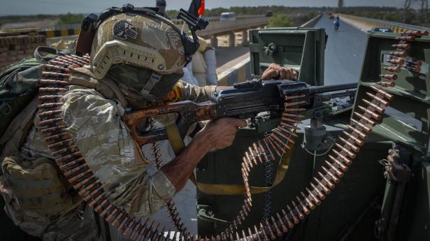 En afghansk soldat holder vagt fra et militærkøretøj uden for et af FN's kontorer i Herat-provinsen lørdag. Herat er en af de provinser, hvor der i disse dage er hårde kampe mellem hæren og Taliban.