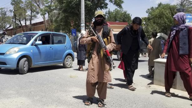 En Taliban-kriger stiller op til fotografering i byen Ghazni, som den militante bevægelse indtog torsdag.