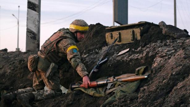 En ukrainsk soldat rækker ud efter en granatkaster uden for storbyen Kharkiv, der ligger nær den russiske grænse.