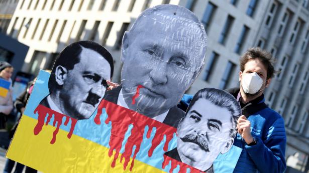 Storbritanniens forsvarsminister er ikke den første, der har sammenlignet den russiske præsident Vladimir Putin med hans forgænger Josef Stalin. Billedet er fra en tysk demonstration mod Ruslands krig i Ukraine, hvor Putin sammenlignes med Stalin og Hitler. Arkivfoto: Fabian Bimmer/Reuters