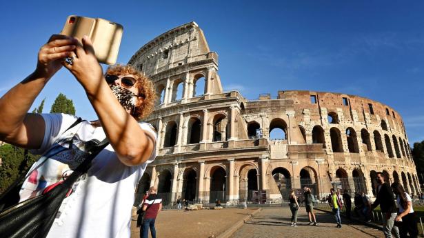 Danmark fraråder nu turistrejser til Italien. Her ses besøgende ved Colosseum i Rom. Foto: Alberto Pizzoli/AFP/Ritzau Scanpix