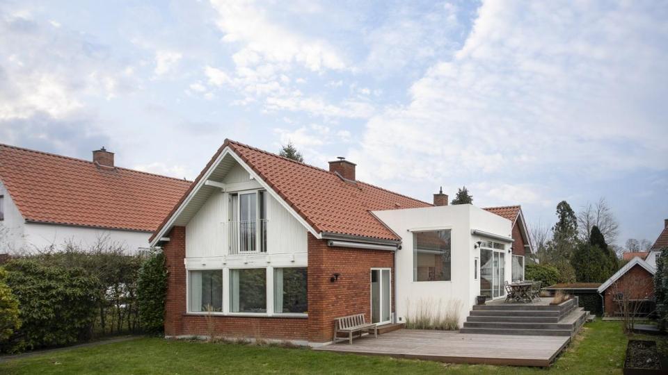 Caroline Overgaard og Mikkel Roseners villa set fra haven med den hvide tilbygning med hjemmets nye køkken, der har tre meter til loftet og ligger på den tidligere havestues fundament.