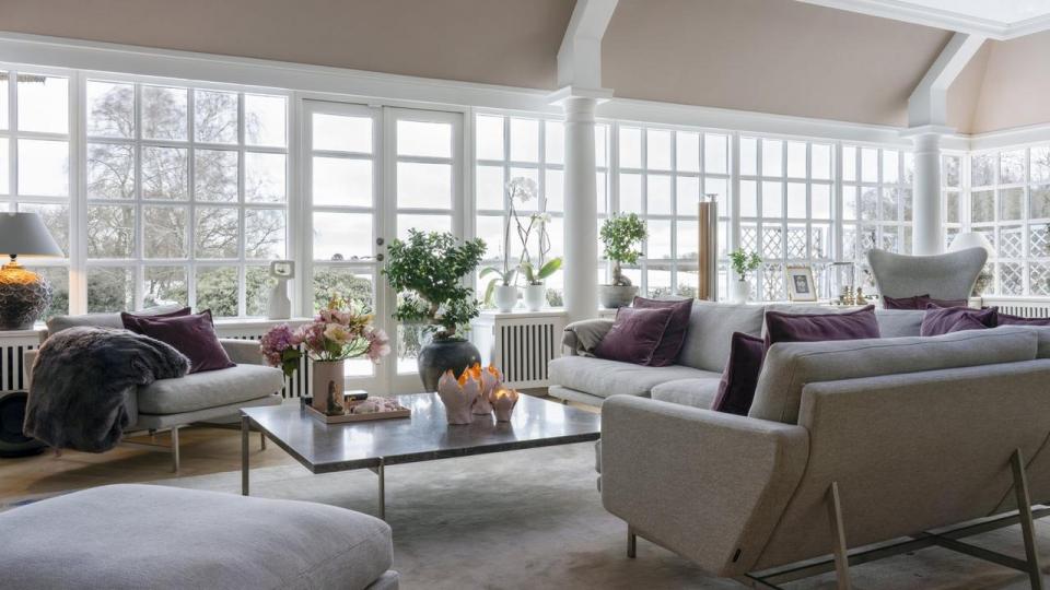 Dagligstuen er indrettet med en sofagruppe designet af Piero Lissoni for Fritz Hansen omkring Poul Kjærholms sofabord i grå marmor og rustfrit stål. På bordet står en samling elementer, der skal skabe en god energi i stuen, placeret på en lakbakke fra Oi Soi Oi. Papirblomsterne er skabt af Pernille Sørensen, Doxaflowers. Både krystaller, buddhaer og lyserøde lysholdere er fra Rikke Hertz Feng Shui Living. Puderne med monogram blev produceret i forbindelse med parrets bryllup.