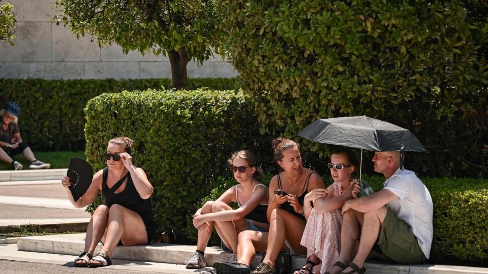 Turister forsøger at køle af i det centrale Athen tirsdag, hvor temperaturer i flere dele af Grækenland har passeret 40 grader for første gang i år. 