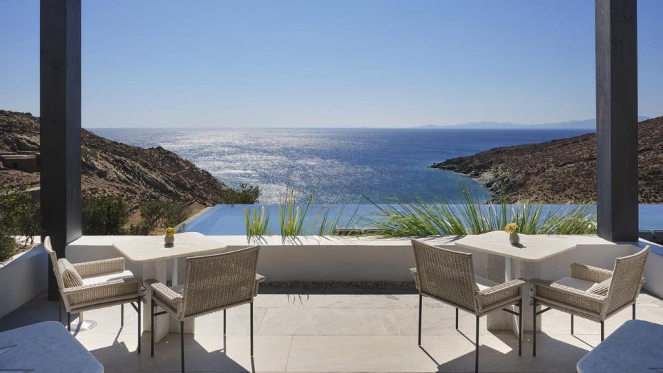 Fra en overdækket terrasse på Odera Tinos er der frit udsyn over bugten og Det Ægæiske Hav. Hotellet ligger isoleret i det tørre, klippefyldte landskab på øen Tinos.