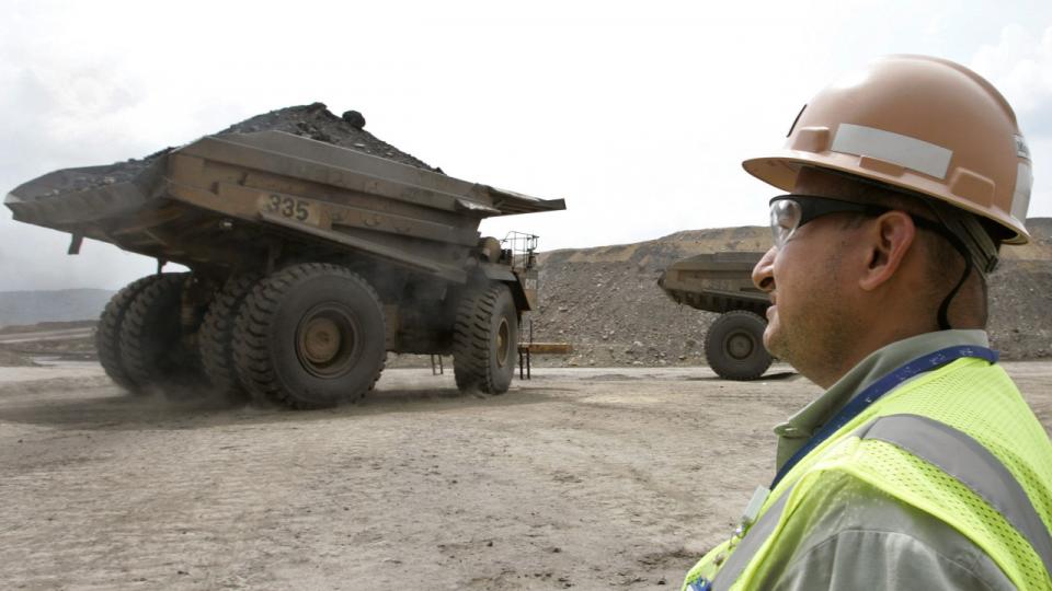 En colombiansk arbejder ser minelastvognene køre væk fra Carrejón-kulminen, der er ejet af BHP, Glencore og Anglo American. Arkivfoto: Jose Miguel Gomez/Reuters/Ritzau Scanpix