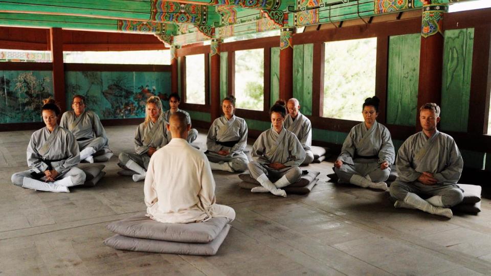 De ni deltagere i “Shaolin” sammen med en af deres masters. Meditation og kampsport er grundelementer i personlig udvikling.