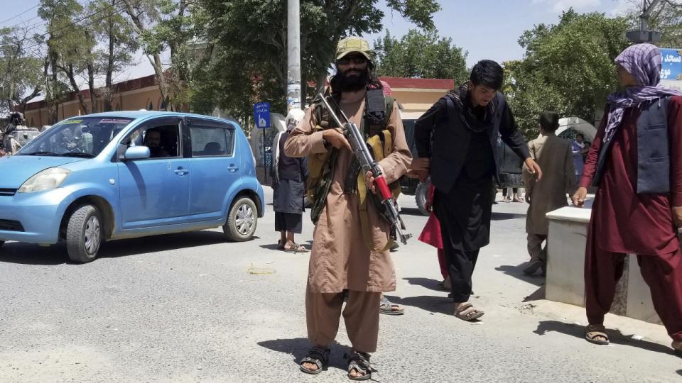 En Taliban-kriger stiller op til fotografering i byen Ghazni, som den militante bevægelse indtog torsdag.